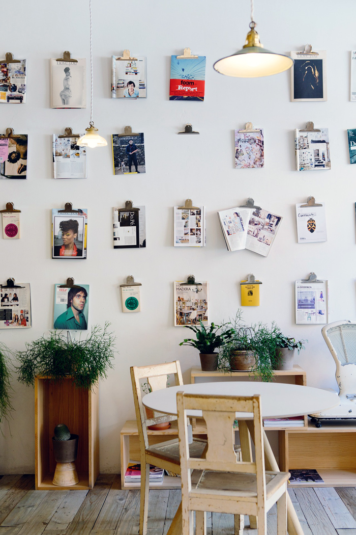 A display on a wall that holds magazines and catalogs, presumably to plan shopping and styles